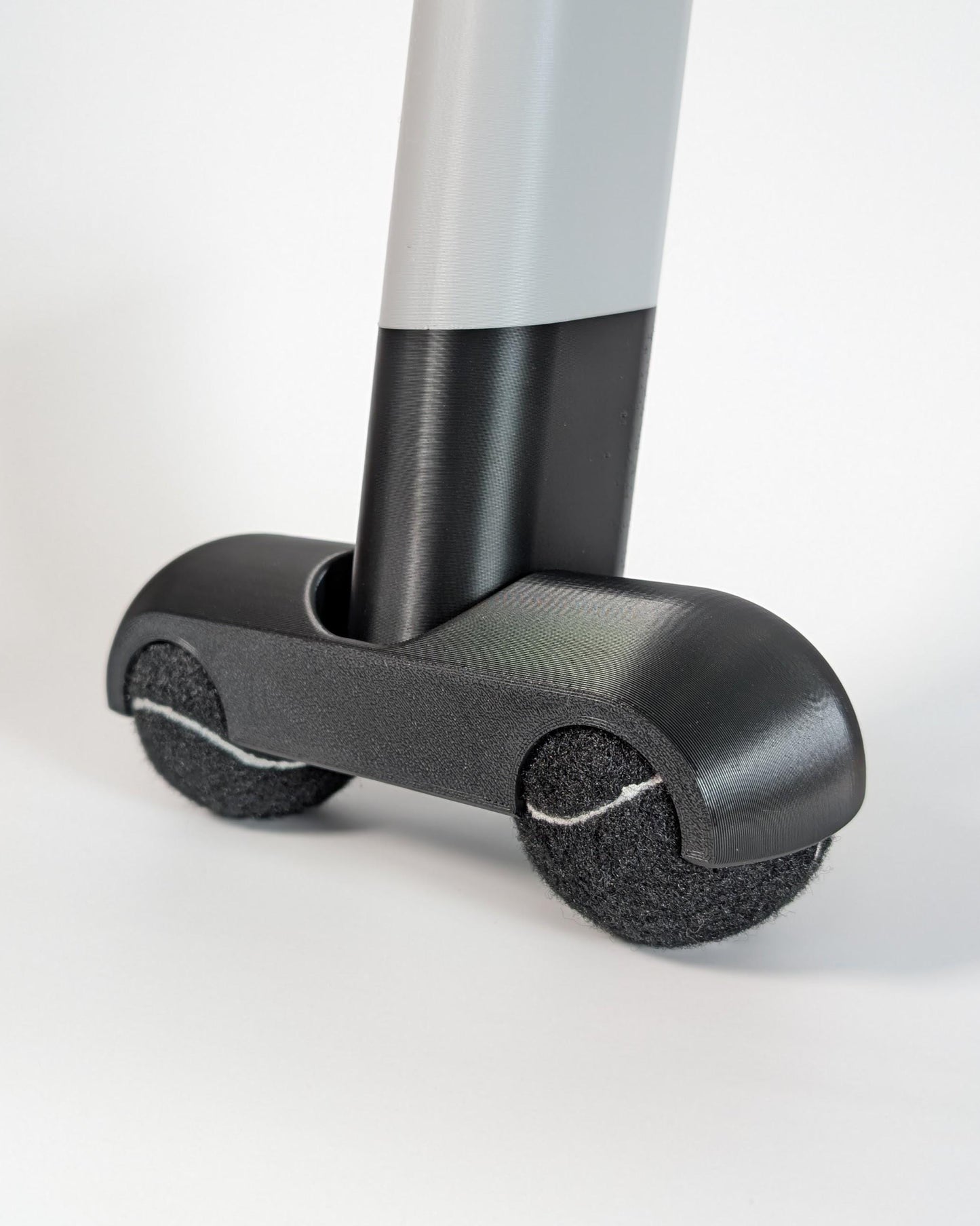 Zwift ride rocker feet with black tennis balls on a white background