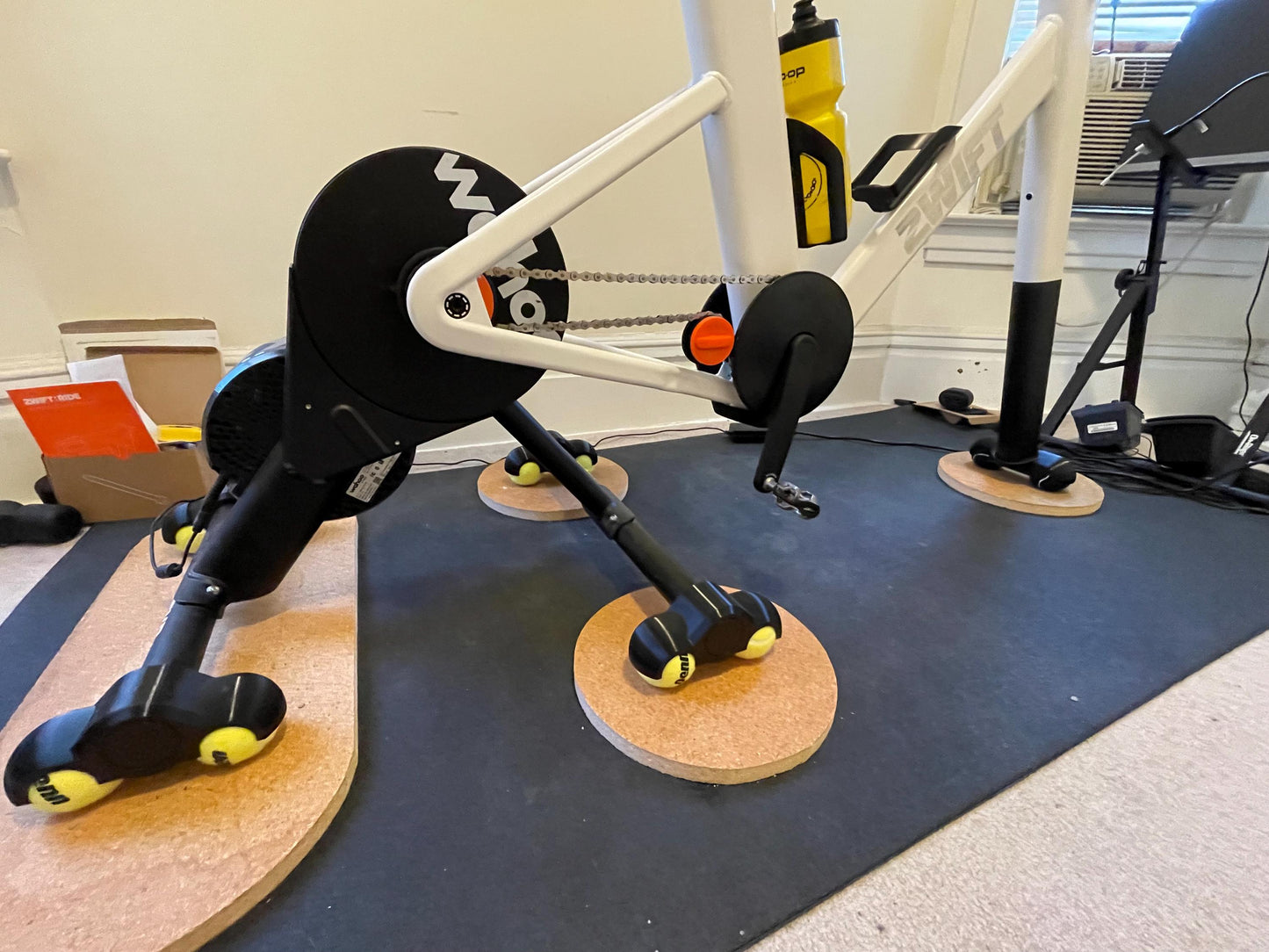 Exercise bike on a mat in a home gym setting with a wahoo kickr core and rocker feet