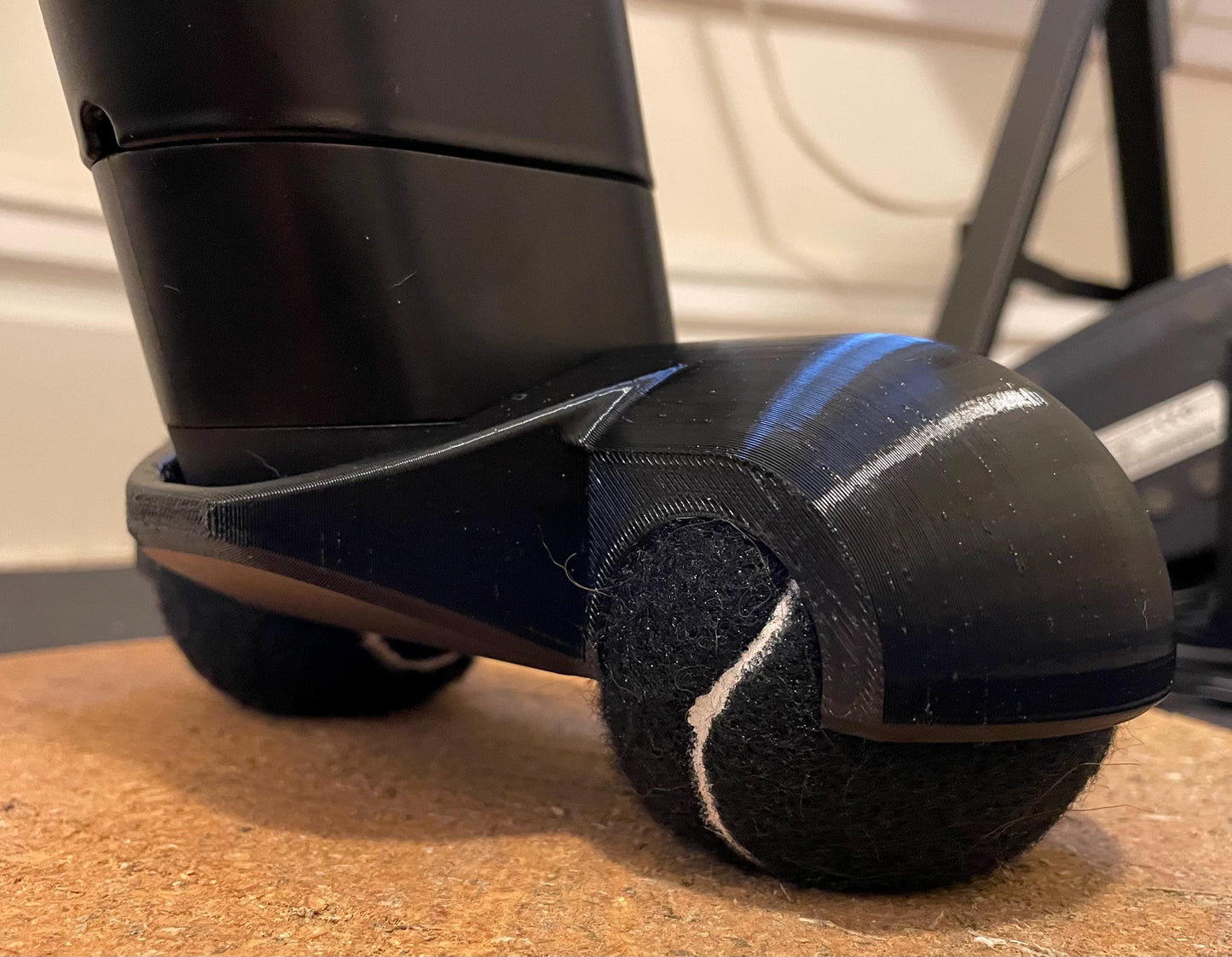 close up of a Zwift ride rocker foot with black tennis balls