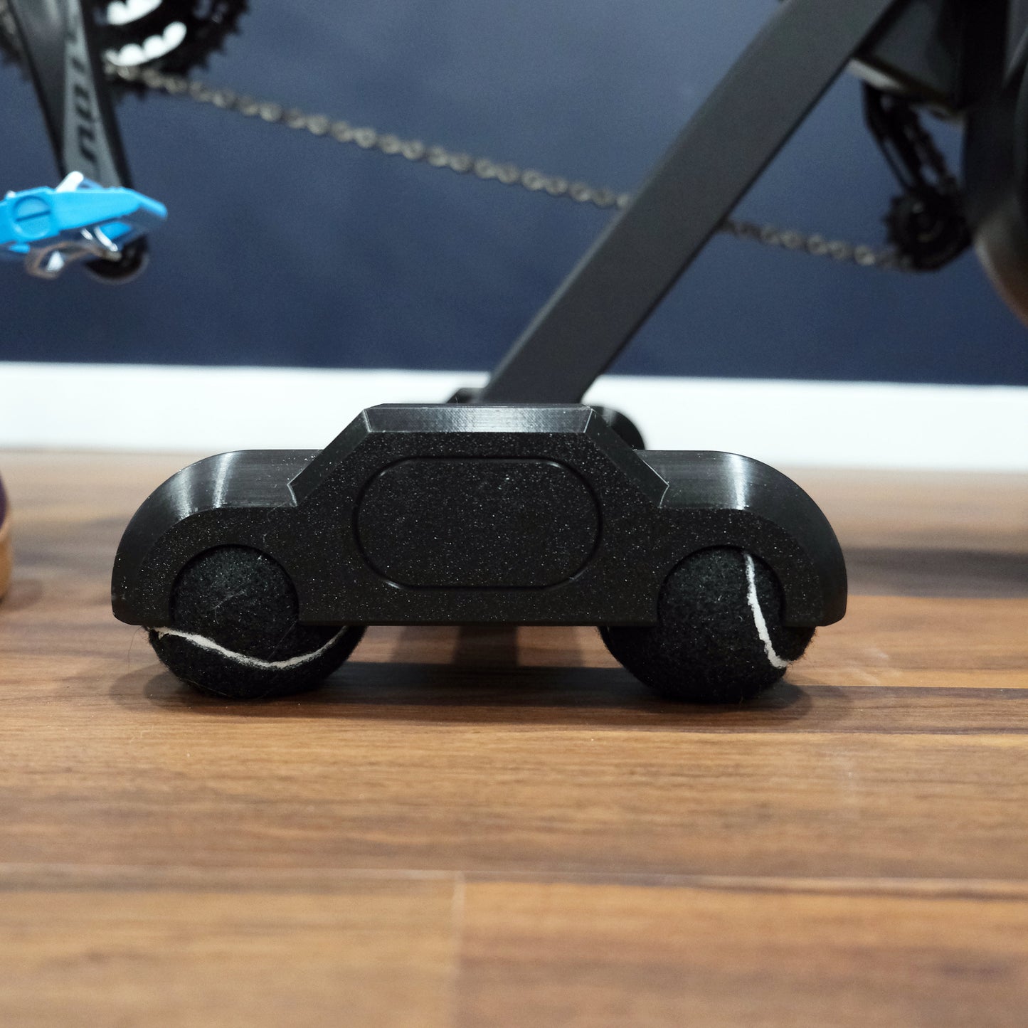 close up of rocker feet with black tennis balls for a zwift hub one indoor trainer