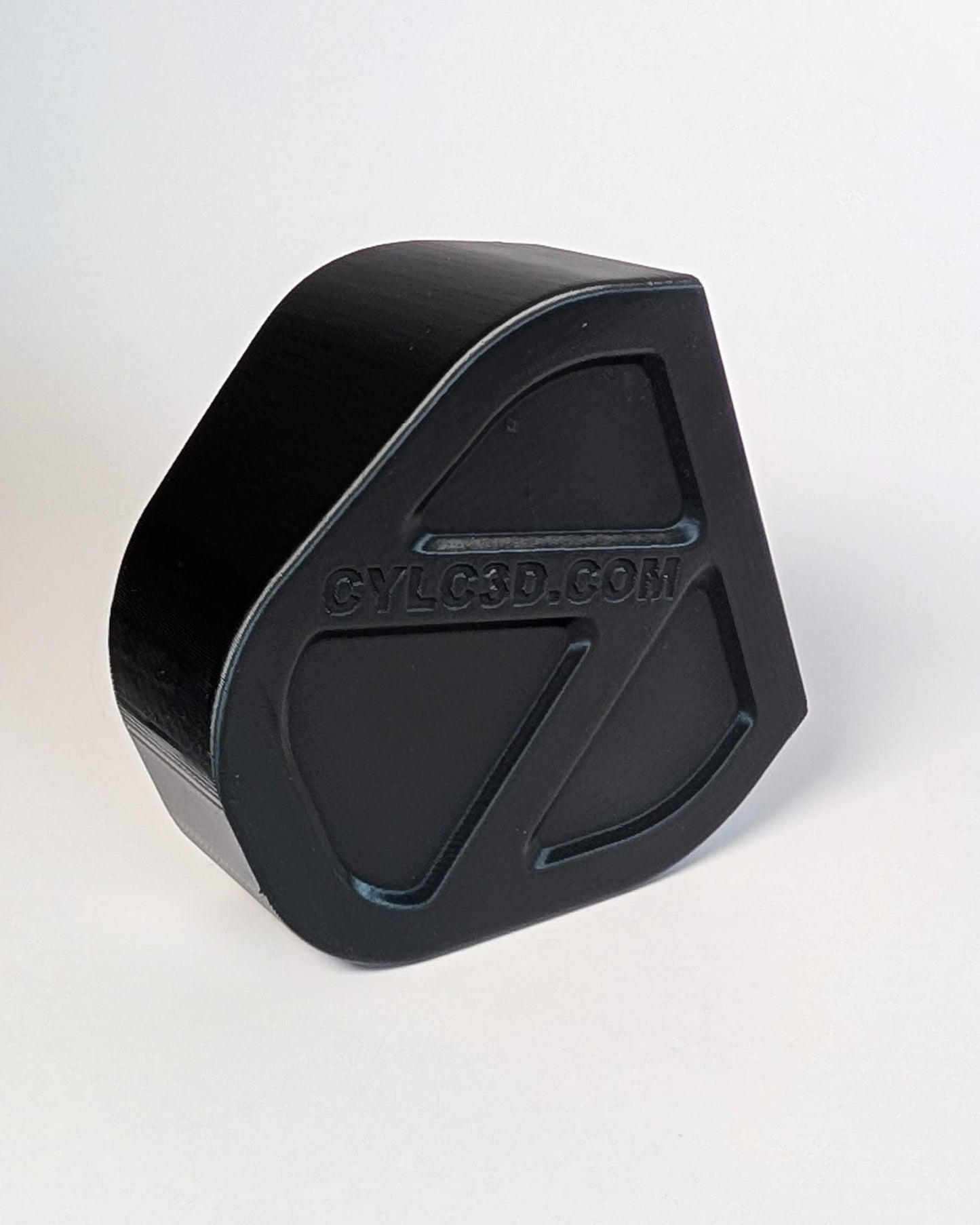 Black hexagonal object with 'CYLC3D.com' text on a white background