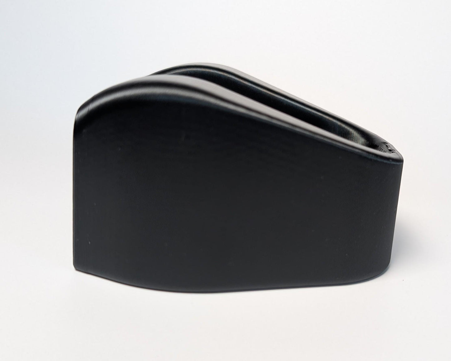 black riser block with a streamlined aerodynamic shape on a white background
