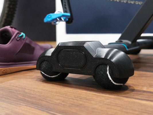 rocker feet with black tennis balls for the zwift hub one with a crank bros shoe in the background